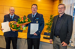 Ortsbrandmeister Ansgar Osterbrink (links) und sein Stellvertreter Lothar Gödeker nehmen die Ernennungsurkunden samt Blumen von Bürgermeister Otto Steinkamp entgegen.