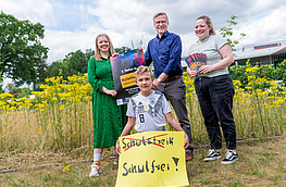 Lilian-Ruth Sasse (Ratsmitglied), Bürgermeister Otto Steinkamp und Jugendpflegerin Pia Bode und Schüler Kane Weelborg mit dem Plakat zur Jugendkonferenz.