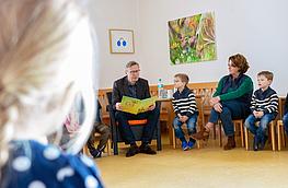 Im Stuhlkreis liest Bürgermeister Otto Steinkamp den Vorschulkindern des St. Johannes-Kindergartens vor.