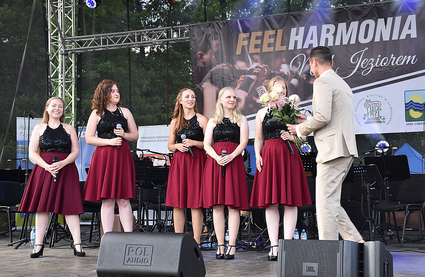 Stawigudas Bürgermeister Michał Kontraktowicz dankt den Sängerinnen mit Blumen.