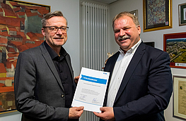 Dr. Reinhold Kassing (rechts) überreicht Bürgermeister Otto Steinkamp die VKU-Mitgliedsurkunde.