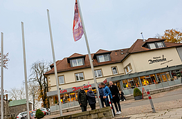 Bürgermeister Otto Steinkamp, Sabine Stenzel, André Schwegmann, Hans Stegemann und Michael Lührmann (von links) hissen die Fahne „Nein zu Gewalt gegen Frauen“ vor dem Wallenhorster Rathaus.