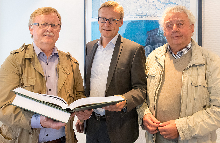 Karl-Heinz Bergmann, Bürgermeister Otto Steinkamp und Hans Riepenhoff (von links) mit der gebundenen Jahresausgabe des „Bürger-Echos“.