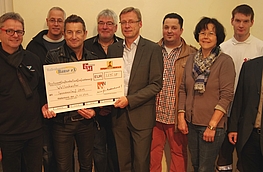 Hans-Jürgen Klumpe (3. von links), Vorsitzender von „Wir für Wallenhorst“, und Bürgermeister Otto Steinkamp (7. von links) überreichten einen symbolischen Scheck am John McGurk (5. von links) und die Vertreter der Wallenhorster Vereine.