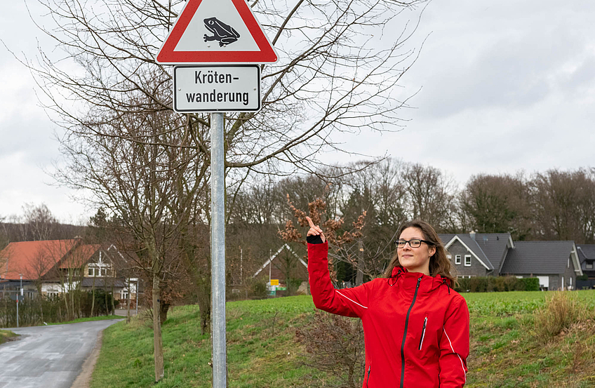 Wallenhorsts Umweltbeauftragte Isabella Draber weist auf die neuen Warnschilder am Eingang der Siedlung in Brockhausen hin.