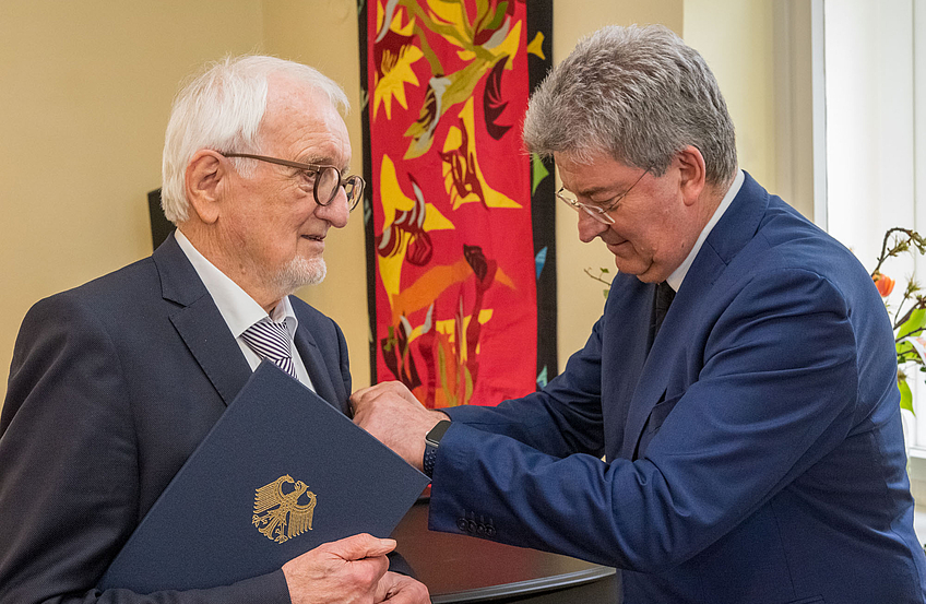 Kreisrat Matthias Selle überreicht Erich Goer das Verdienstkreuz am Bande.