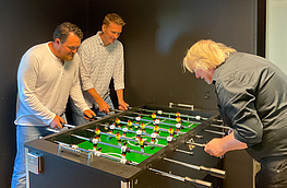 Alex Braun und Rudolf Stromann (von links) von der IPW spielen am Kickertisch gegen Jugendpfleger Jürgen Abeln.