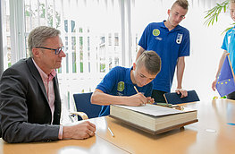 Mannschaftskapitän Kacper Zcwejko war der erste, der sich im Beisein von Bürgermeister Otto Steinkamp (links) ins Goldene Buch eintrug, seine Teamkollegen folgten.