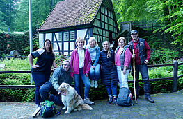 Nadine Levermann (Bad Essen), Dirk Meyer mit Regionsmaskottchen „Cooper“ (Belm), Angelika Hoffstädt (Tourismusgesellschaft Osnabrücker Land), Anette Lange (Bohmte), Maike Schlichting (Ostercappeln), Christiane Wagner (Bramsche) und Michael Hein, Wanderkoordinator beim Natur- und Geopark TERRA.vita, vor der Wassermühle in Bad Essen.