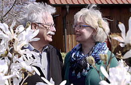 Kein Geheimnis: Gärtnern macht glücklich – auf jeden Fall Debbie und Jochen Prüfer in ihrem „Secret Garden“, hier hinter blühenden Magnolien. Foto: Tourismusverband Osnabrücker Land e.V.