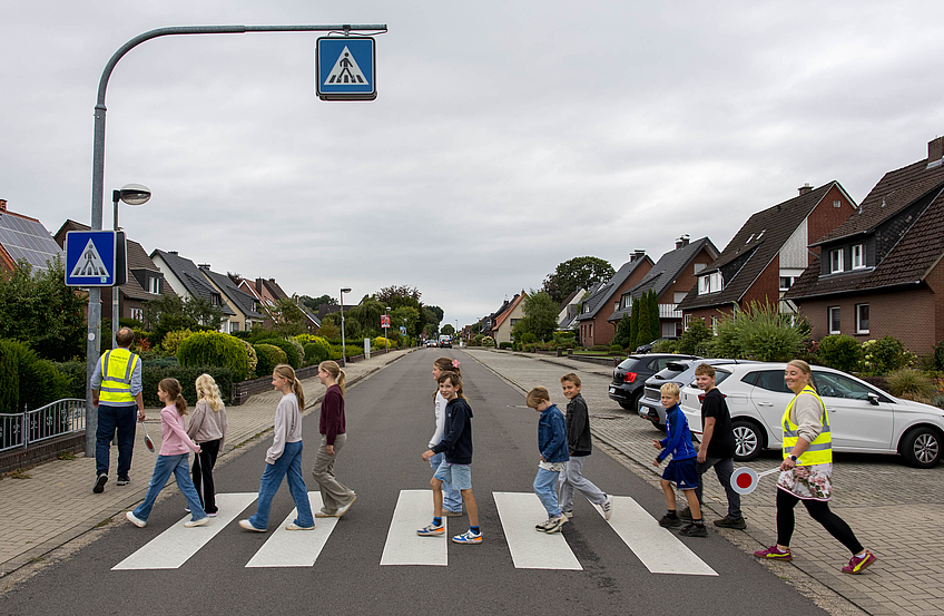 Kinder gehen in einer Gruppe über die Straße.