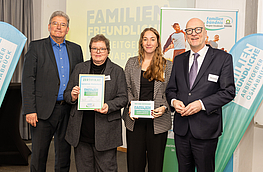 Marlies Albers und Leonie Winter nehmen das Zertifikat „Familienfreundliche Arbeitgeber“ von Kreisrat Matthias Selle und Wolfgang Beckermann, Erster Stadtrat der Stadt Osnabrück, entgegen.