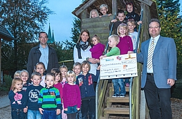 Stefan Ludwig (links), Britta Osterfeld (Mitte) und Frank Jansing bei der Spendenscheckübergabe umrahmt von einigen Kindern des Kindergartens St. Johannes in Rulle.