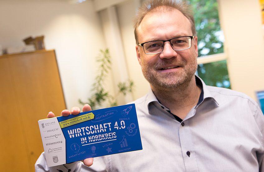 Wallenhorsts Wirtschaftsförderer Frank Jansing präsentiert den Flyer „Wirtschaft 4.0 im Nordkreis“.