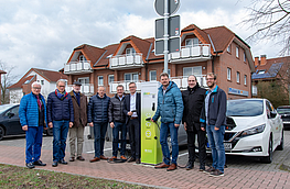 Bürgermeister Otto Steinkamp (4. von rechts), Björn Fütz (2. von rechts) und Stefan Sprenger (rechts) nehmen die E-Ladesäule gemeinsam mit Vertretern der Ratsfraktionen in Betrieb.