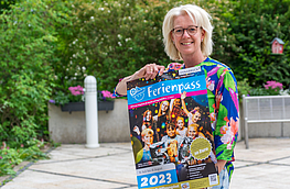 Christina Middendorp vom Familienservicebüro mit dem Plakat zum Osnabrücker Ferienpass