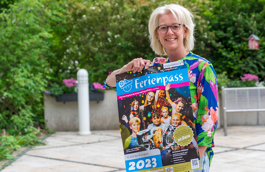Christina Middendorp vom Familienservicebüro mit dem Plakat zum Osnabrücker Ferienpass