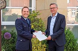Bürgermeister Otto Steinkamp (rechts) überreicht Timo Wischmeier-Raffelt die Ernennungsurkunde.