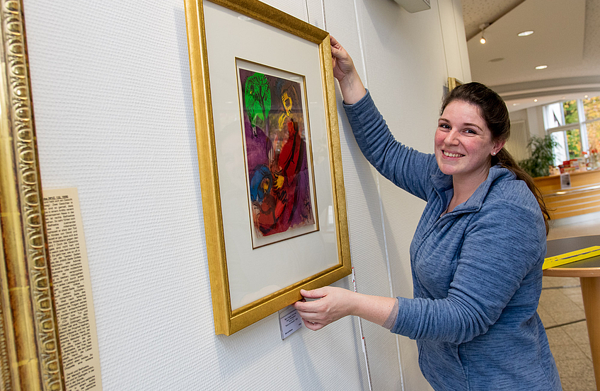 Nina Ollmert (Kunsthandlung Hülsmeier) hängt die Lithographien im Foyer des Wallenhorster Rathauses auf.